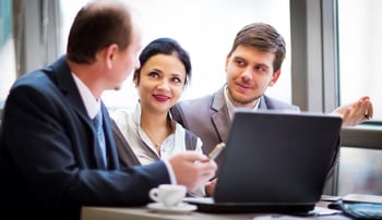 Coworkers_reviewing_content_on_laptop_meeting