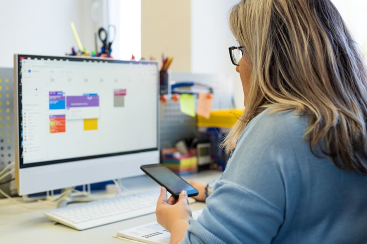 woman reviewing her work calendar and schedule at her desk