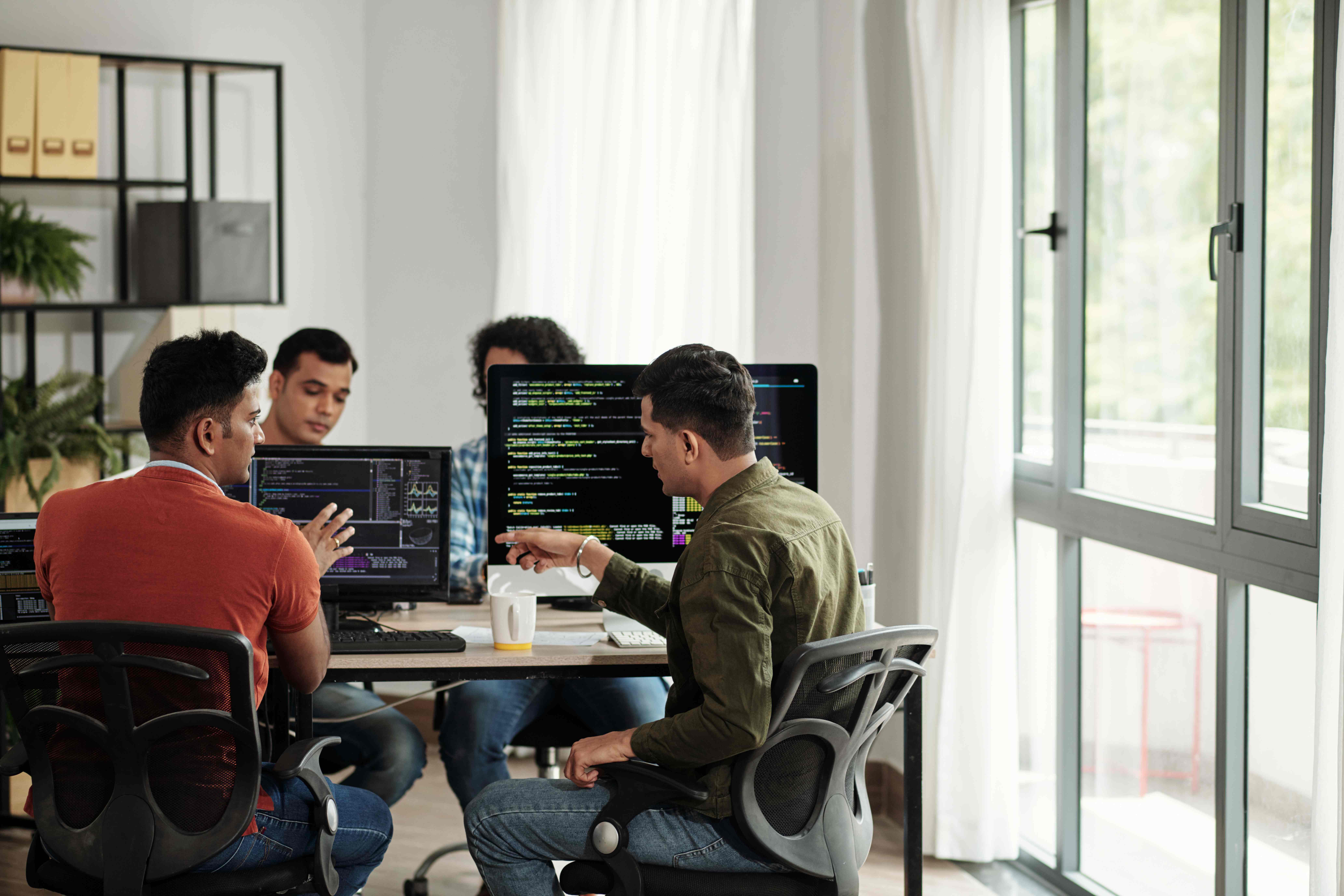 Software developers discussing programming code_516314331