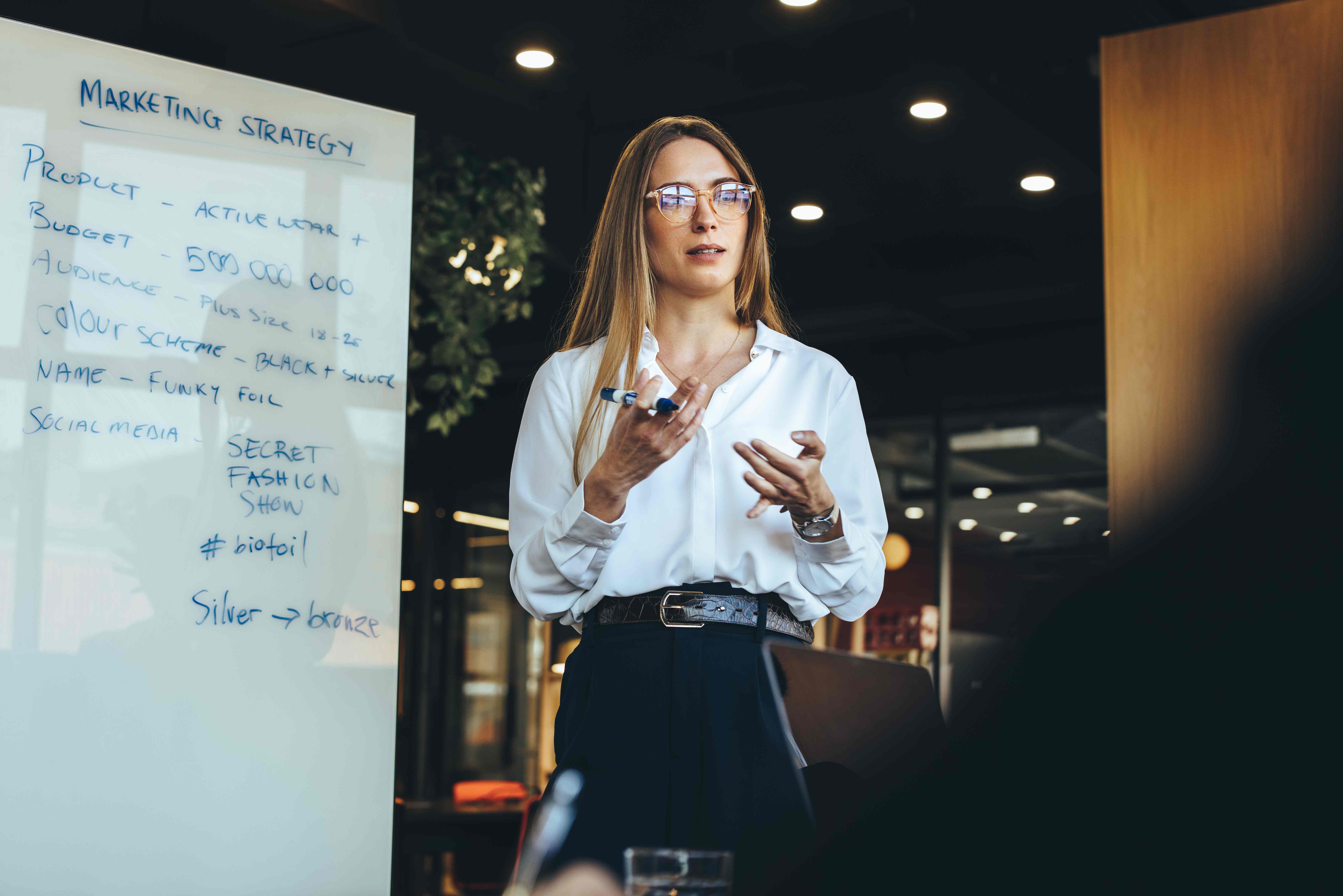 entrepreneur discussing her marketing strategy with her team_563839468